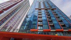 Ein Hochhaus mit mehreren Stockwerken, großen Fenstern und einem modernen architektonischen Design.