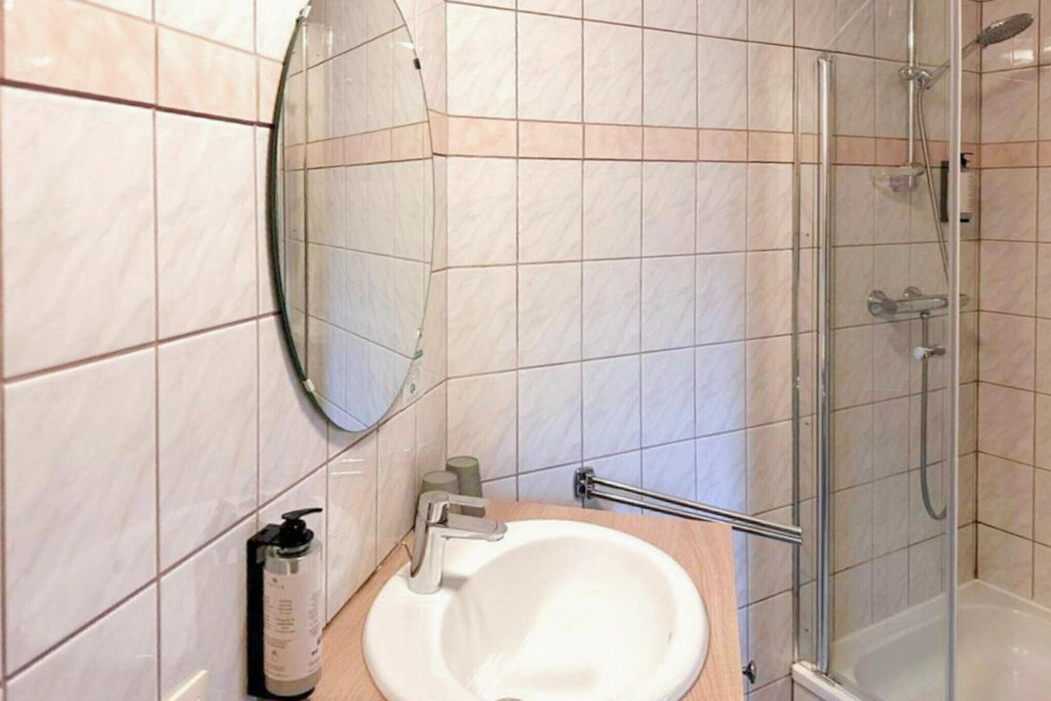 Une salle de bain avec un lavabo, un miroir et une douche.