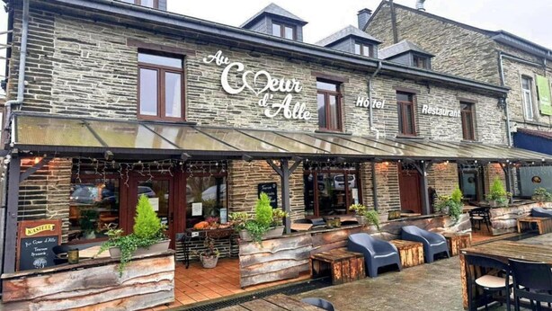 Un bâtiment en pierre sur lequel on peut lire l’inscription : « Au Cœur d’Alle, hôtel-restaurant ».