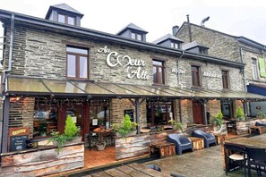 Un edificio de piedra con un cartel que dice 'Au Coeur d'Alle Hotel Restaurant'.