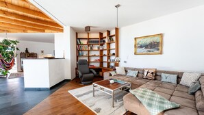 A modern living room with a sofa, coffee table, and a bookshelf. - Chalet Innerwald (Gnadenwald)