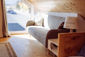 A cozy room with a bed, a bedside table with a lamp, and a view of the outdoors.