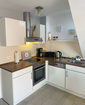 Réfrigérateur, un four, surface de cuisson, lave-vaisselle