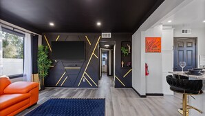 Ein modernes Interieur mit einer Couch, einer Bar und einem Fernseher.