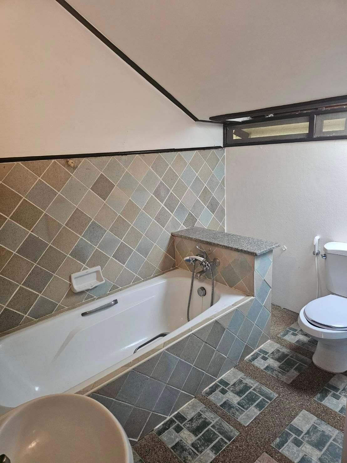 A bathroom with a bathtub, a toilet, and a sink.