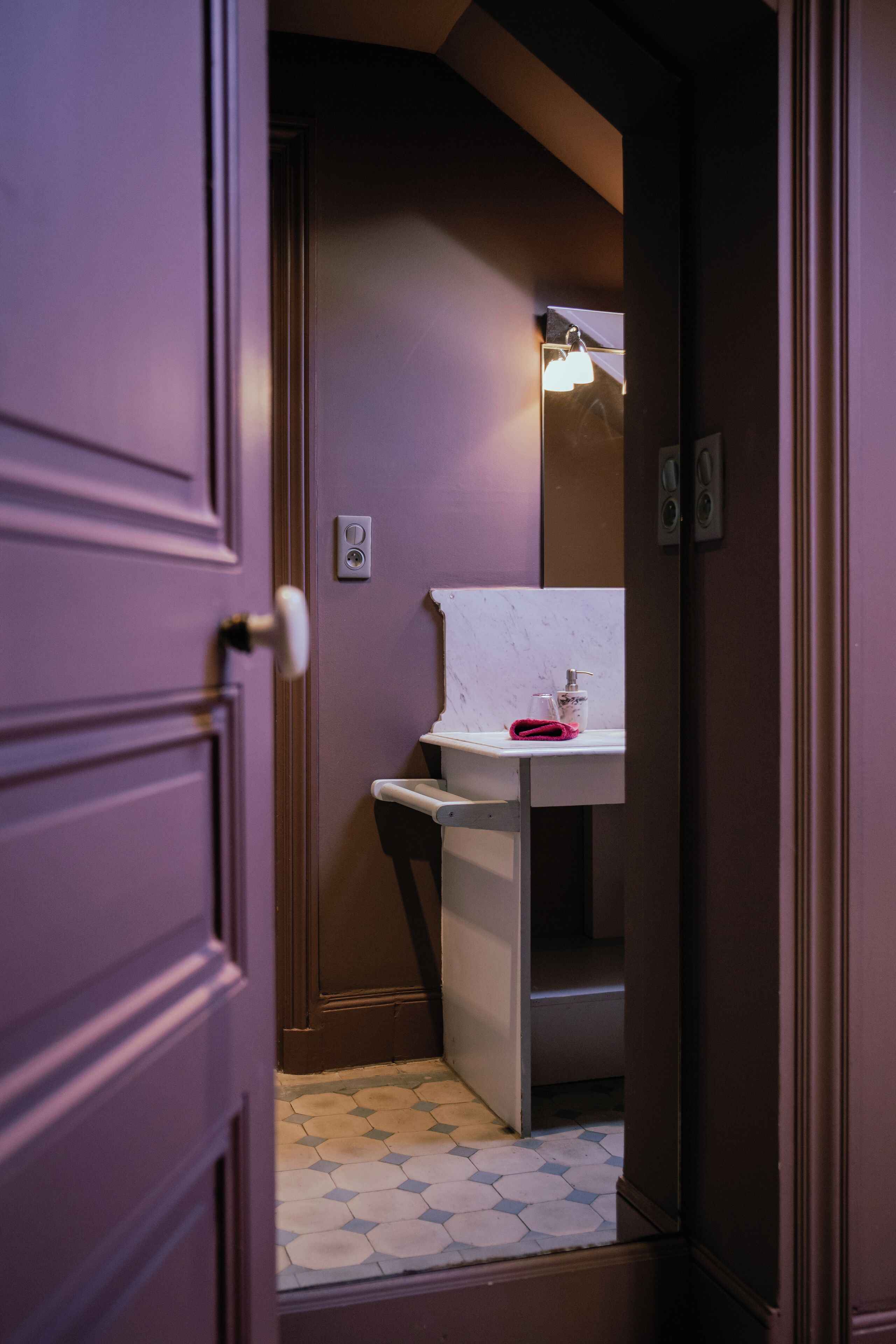 A bathroom with a white sink, a mirror, and a towel rack.
