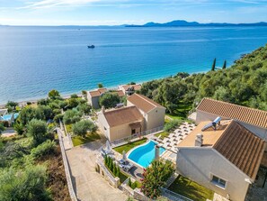 A coastal property with a swimming pool, terraced roofs, and a view of the sea. - Villa Odysseus in Ionian Islands (Corfu)