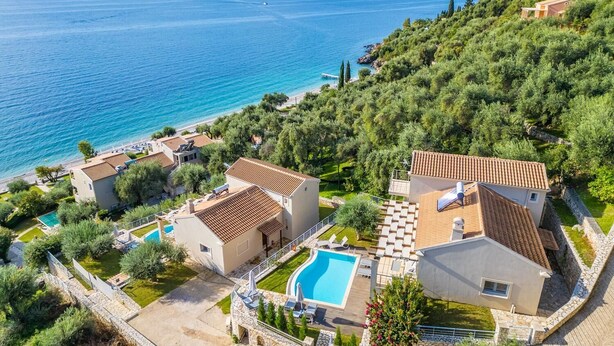 Una proprietà costiera con diverse ville, una piscina e vista mare.