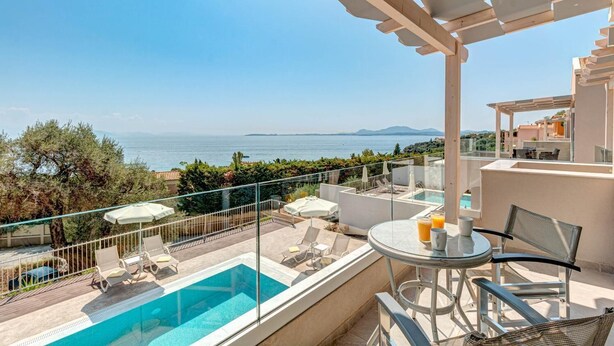 A balcony with a pool, outdoor furniture, and a view of the sea. - Villa Stavroula in Mparmpati (Corfu)