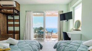 A room with two beds, a TV, a mirror, and a balcony with a view of the sea. - Villa Stavroula in Mparmpati (Corfu)