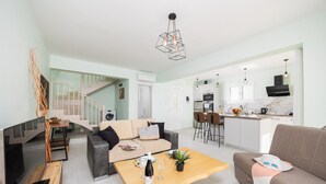 Um apartamento moderno com sala de estar, área de jantar, cozinha e escada.