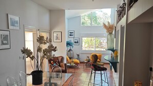 A spacious living area with a dining table, chairs, and a sofa. There are framed pictures on the walls and a large window providing natural light. - 6-hectare estate classified as a Grand Site de France concors Sainte Victoire (Jouques)