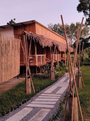 A wooden building with a thatched roof, a bamboo fence, and a gravel pathway leading to it. - Painon Resort KohLanta (Ko Lanta)
