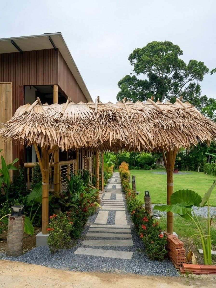 A pathway leading to a building with a thatched roof structure.
