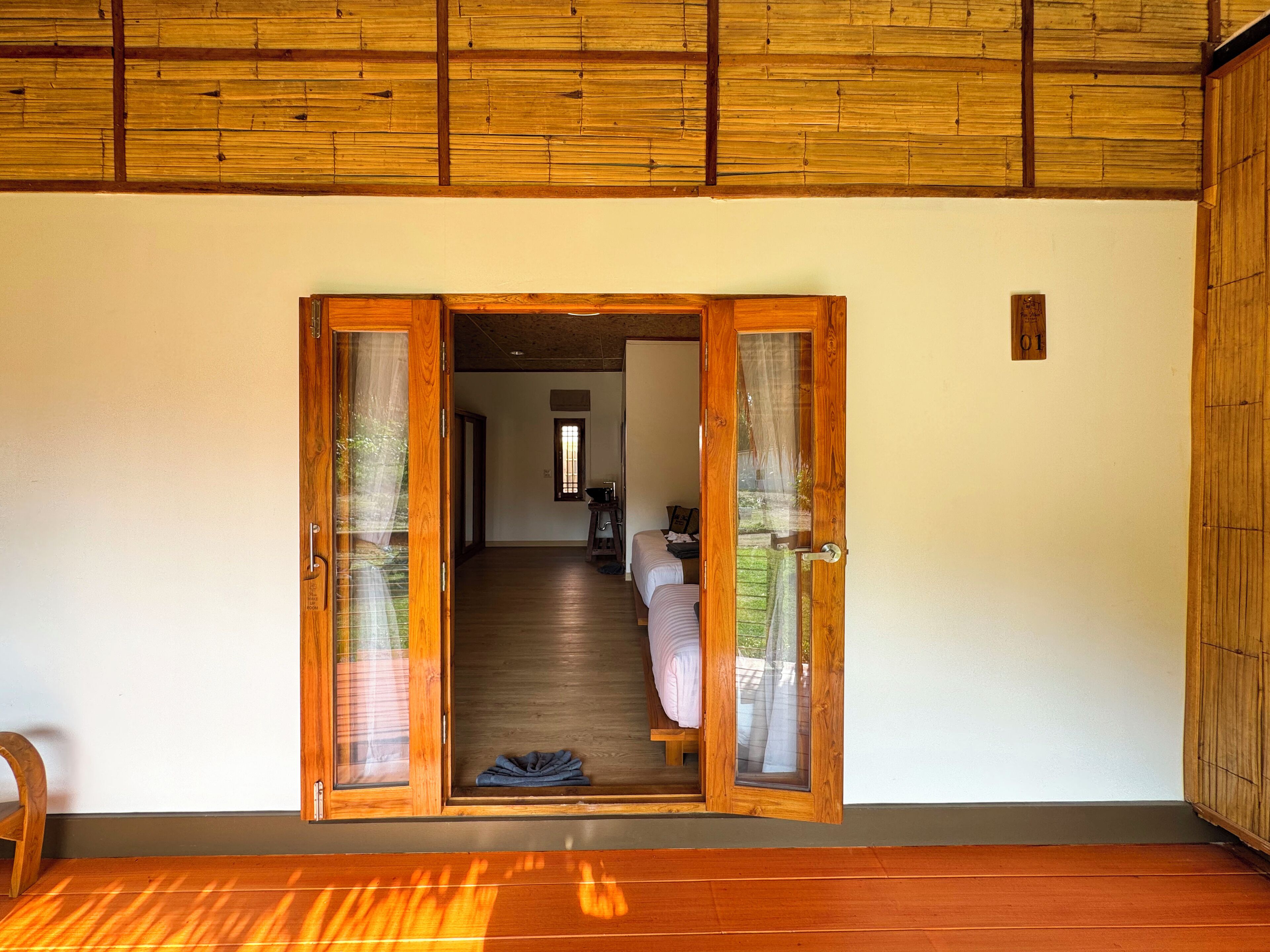 Un vano de madera que da a una habitación con una cama y una mesita.