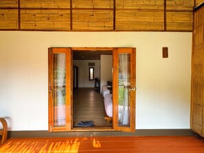 A wooden-framed doorway leading to a room with a bed and a small table. - Painon Resort KohLanta (Ko Lanta)