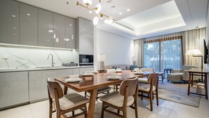 A modern kitchen with a dining area, a flat-screen TV, and a large window with curtains. - 3BR Family Residence w/ Distant Sea View and Assistant Room, Near to Beach (Fujairah)
