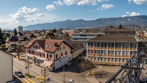 Un quartier résidentiel avec des maisons, une route et des montagnes en arrière-plan.