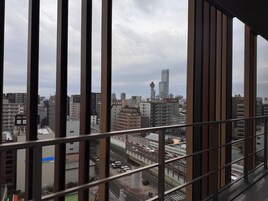 Vista de un paisaje urbano a través de una ventana, con edificios, un puente y una torre.