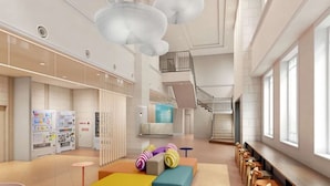 Eine großzügige Lobby mit Verkaufsautomaten, einer Treppe und Sitzbereichen.