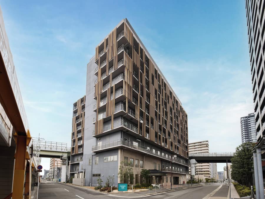 Un edificio de varios pisos con balcones, una entrada cubierta y un cartel que indica Centara Life.