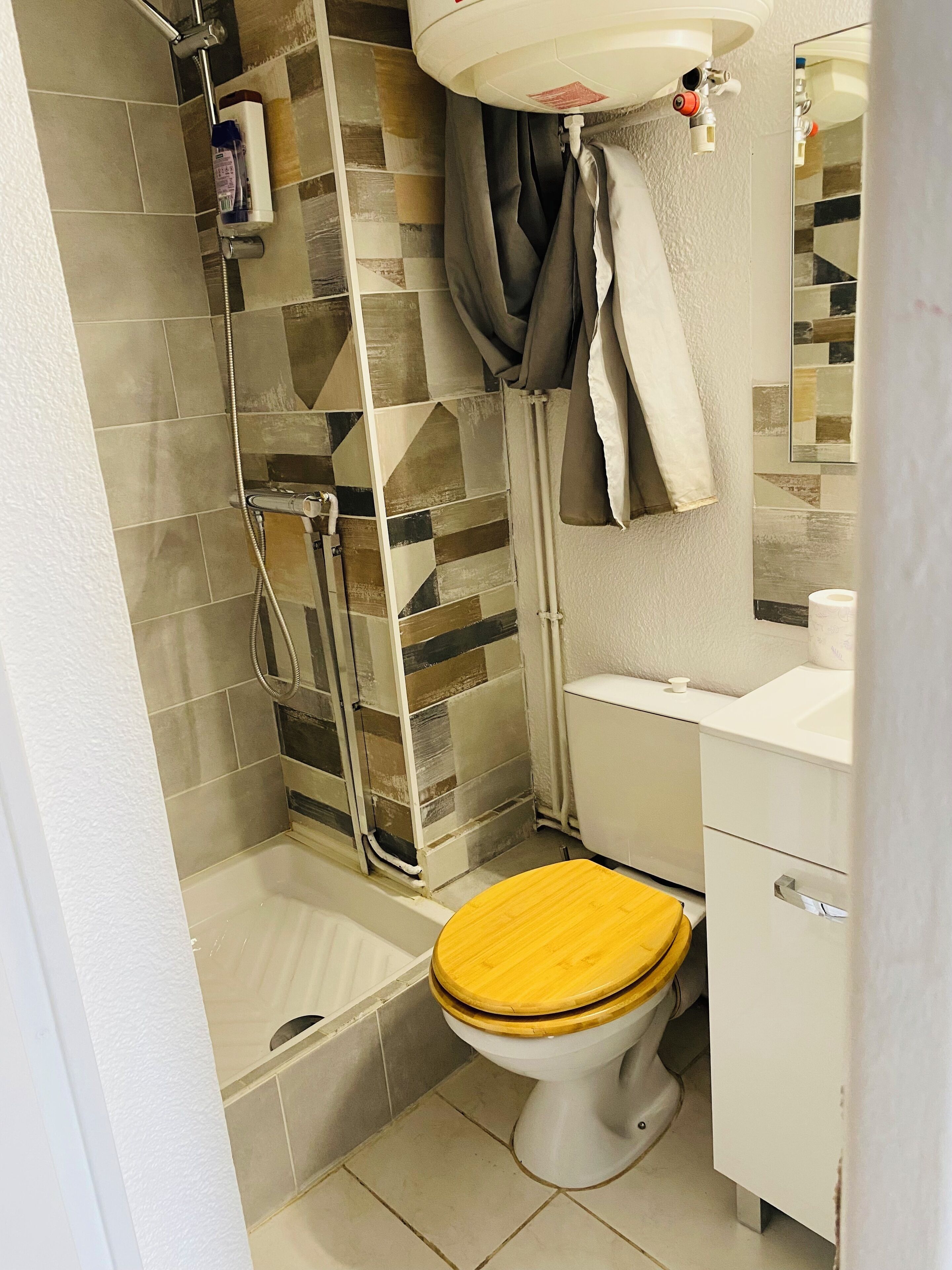 A bathroom with a shower, toilet, and sink.