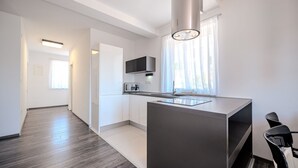 Une cuisine moderne dotée d’un îlot central, d’un four à micro-ondes et d’un four encastré.