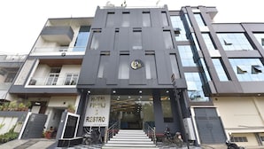 A modern hotel entrance with a sign for "Hotel Priyaj & Restro". - Ricch Hotels (Jaipur)