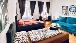 Ein modernes Wohnzimmer mit einer Couch, einem blauen Sofa und einem Essbereich.