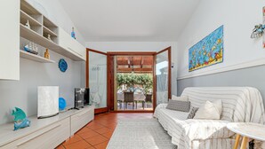 A living room with a sofa, a coffee table, a TV, and a bookshelf. - Holiday Home 'Villetta Via Tempio' with Private Terrace, Private Garden and Air Conditioning (San Teodoro)