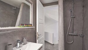 A modern bathroom with a white sink, a large mirror, and a shower area. - Superior Windmill with a private jacuzzi (FC2M+X3 Imerovigli, Greece)
