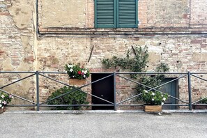 A weathered brick building with a metal gate and potted plants. - CAMPOREGIO 31 - in the center with a view of the Duomo (Siena)
