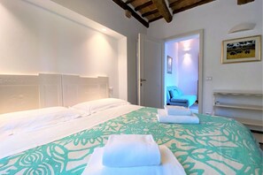 A hotel room with a large bed, a headboard, and a door leading to a bathroom. - CAMPOREGIO 31 - in the center with a view of the Duomo (Siena)