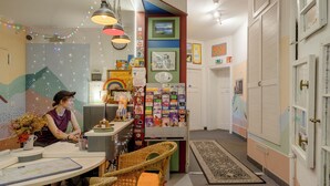 A cozy room with a dining table, wicker chairs, and a small kitchen area. - BackpackerBerlin (Berlin)
