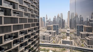 A modern high-rise building with multiple balconies and a cityscape in the background. - 2BR Pool with Burj Khalifa View (Dubai)