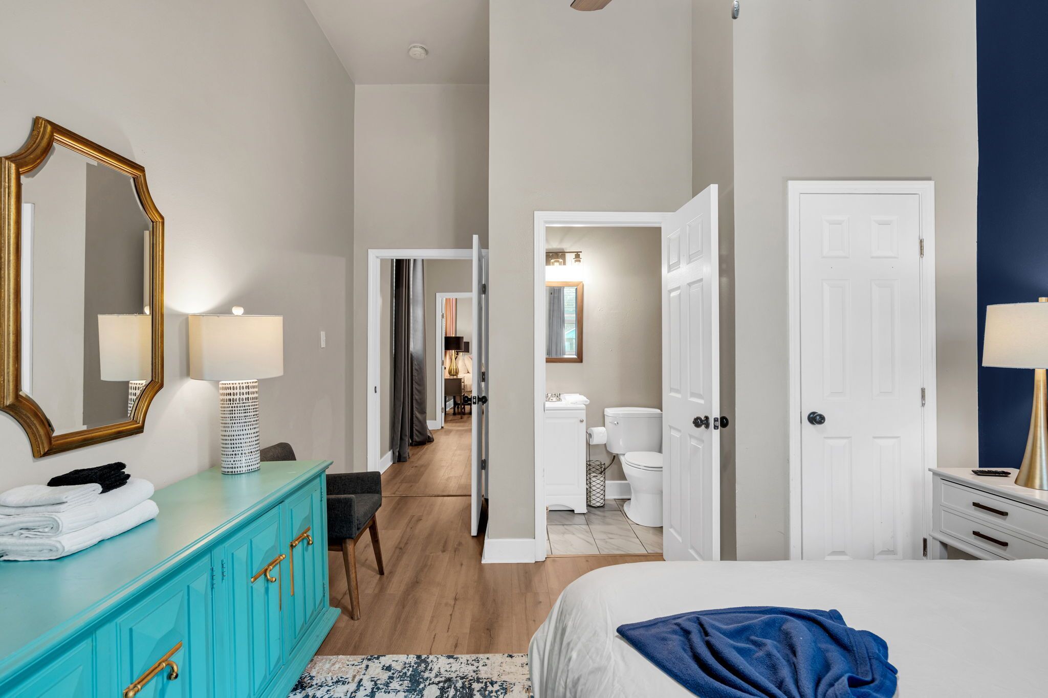 Une chambre d’hôtel comprenant un lit, une salle de bain avec des toilettes et un lavabo, un miroir et une commode.