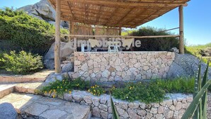 Un espacio de estar al aire libre cubierto con un muro de piedra y plantas.