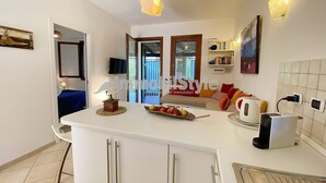 Una cocina moderna con armarios blancos, una isla central y una cafetera.