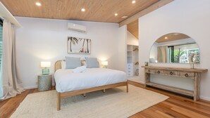 Ein Schlafzimmer mit einem hölzernen Bett, einem großen Spiegel und einem Kleiderschrank.