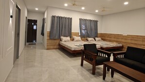 A spacious living area with a high ceiling, recessed lighting, and a modern design. - Hotel Mauris & Restaurant By Wishotel  (Indore)