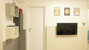 Ein modernes Wohnzimmer mit einem an der Wand befestigten Flachbildfernseher, einer Tür und einer Treppe.