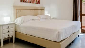 Una cama bien hecha con sábanas blancas en una habitación de diseño sencillo y limpio.