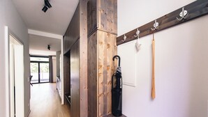 A hallway with wooden paneling, a coat rack with hooks, and a bench. - GH Luxury Apartments Graz, Kalvarienberg (Graz)
