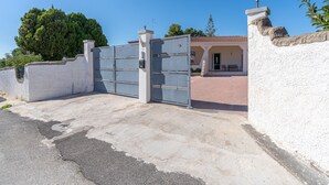 Ein Gebäude mit einem verschlossenen Eingang, einer weißen Mauer und einem Ziegeldach.