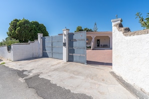 A gated entrance to a building with a white wall and a tiled roof. - Villa 'Fontane Bianche-Private Pool' with Sea View, Wi-Fi and Air Conditioning (Fontane Bianche)