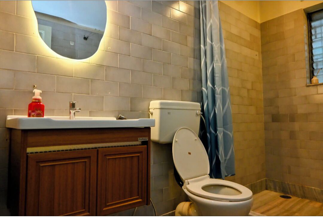 Une salle de bain avec des toilettes, un lavabo et un miroir.