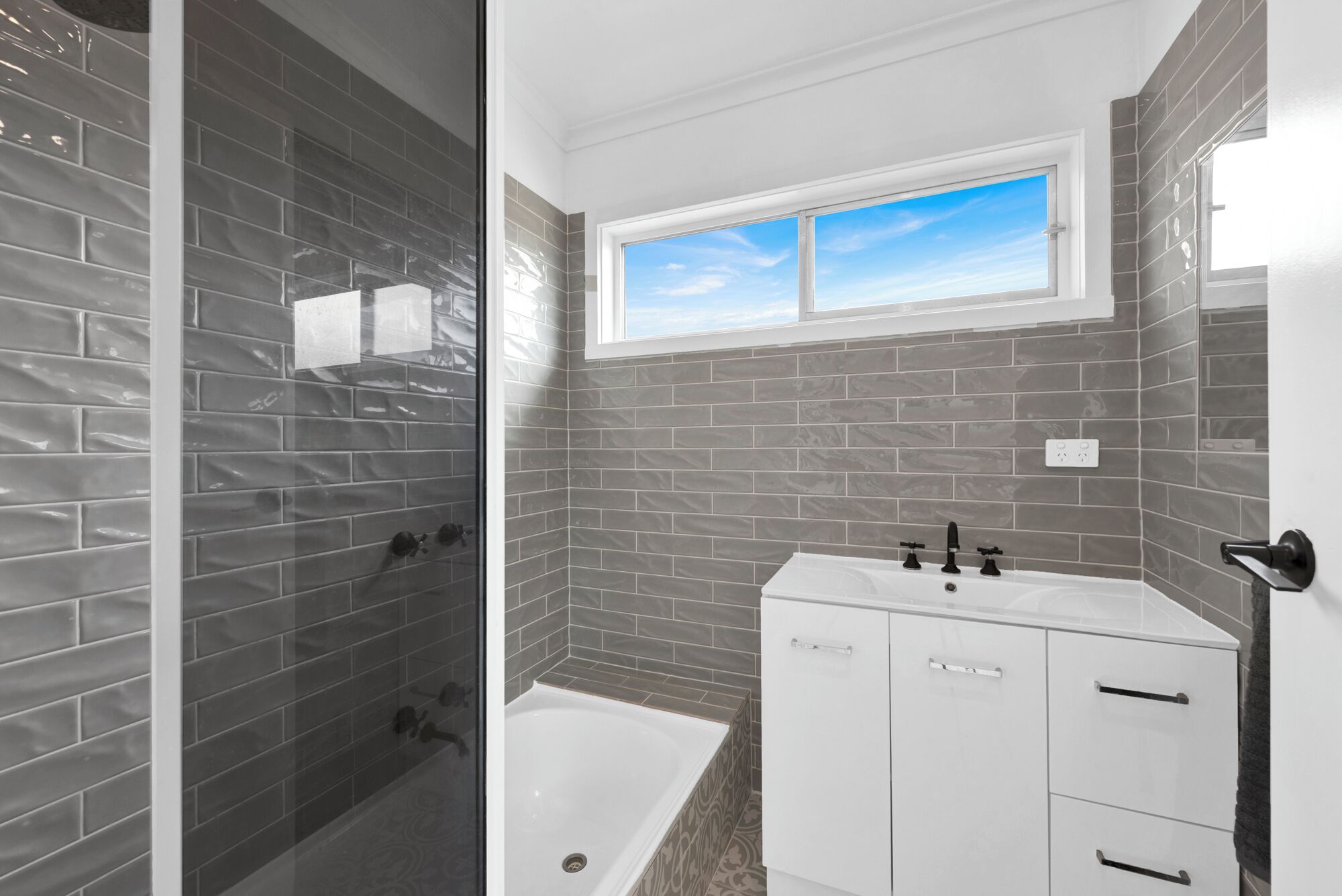 A bathroom with a bathtub, a shower, and a window.
