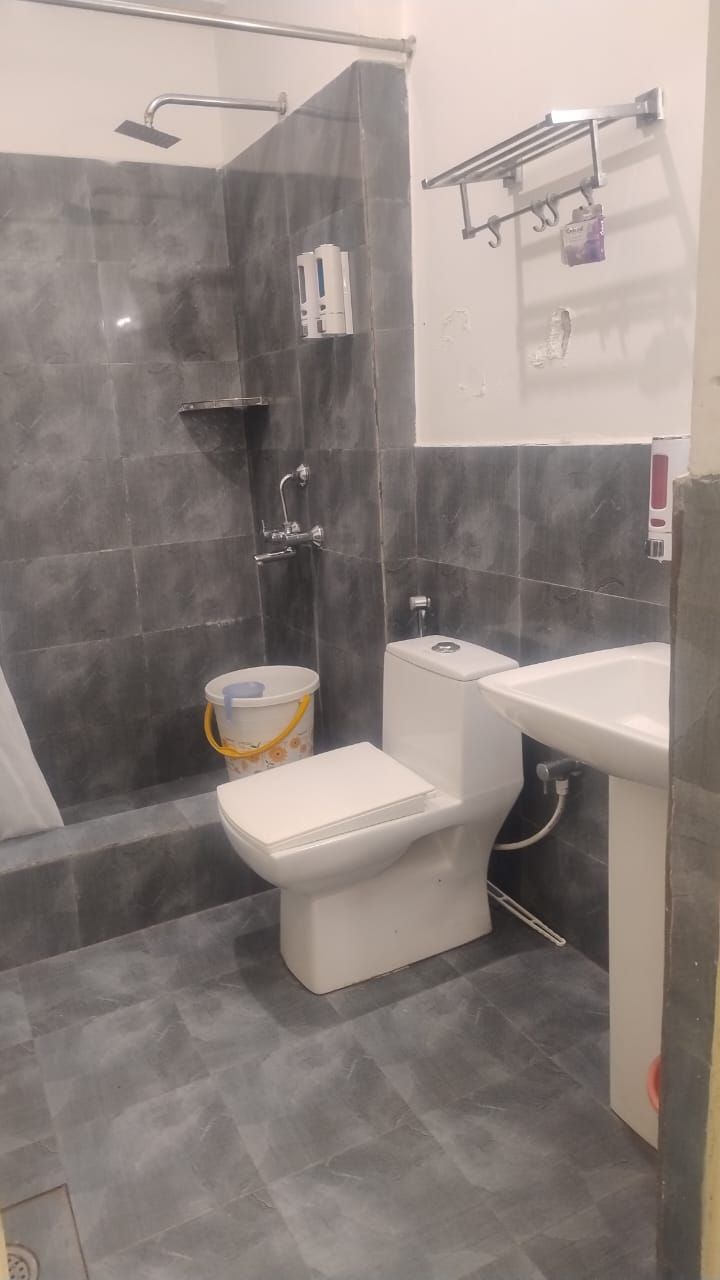 A bathroom with a shower, toilet, and sink.