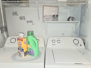 A laundry room with two washing machines, a shelf with a picture frame, and a motivational quote on the wall. - 5 HOSPITALS WITHIN 1O MILE RADIOUS Luxurious 1Bed EXTRA PLUSH! NO PET FEES! (Columbus)