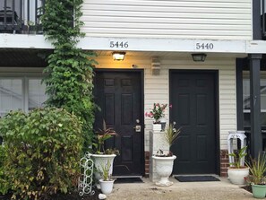 A two-story building with two black doors, numbered 5446 and 5440, and a covered porch area with potted plants. - 5 HOSPITALS WITHIN 1O MILE RADIOUS Luxurious 1Bed EXTRA PLUSH! NO PET FEES! (Columbus)